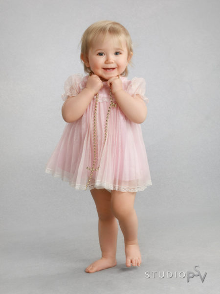 Pieni tyttö vaaleanpunaisessa sifonkimekossaan Studio P.S.V:n lapsikuvassa