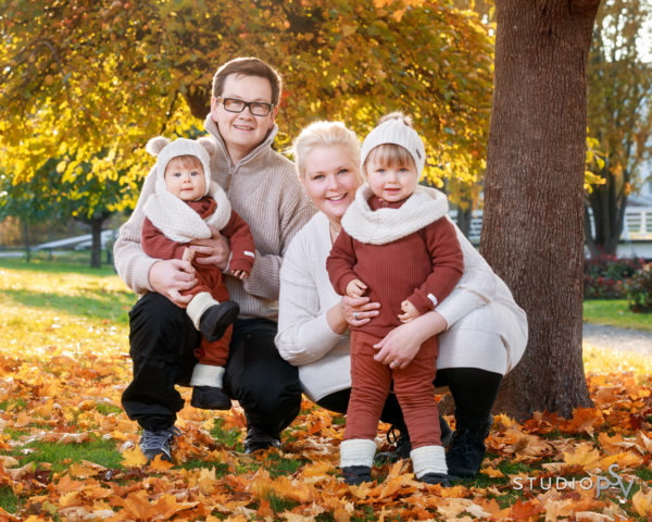 Nelihenkinen perhe ruskan keskellä perhekuvass Ainolan puistossa