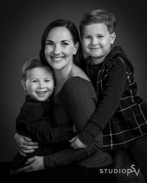 Äiti kahden poikansa kanssa sylitysten Studio P.S.V:n mustavalkoisessa valokuvassa.