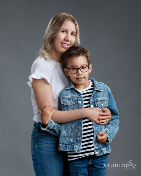 Äiti ja kouluikäinen poika iloisessa yhteiskuvassa, pojalla farkkutakki