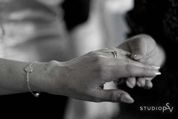 Lähikuva morsiamen kädestä sulhasen kädessä niin, että vihkisormus näkyy.